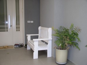 ספסל לבן בכניסה לבית להורדת נעליים