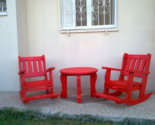 כסאות נדנדה בצבע אדום עם שולחן קפה